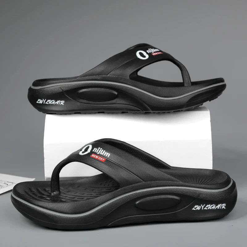 Black sandals with a visible brand logo on a gray background