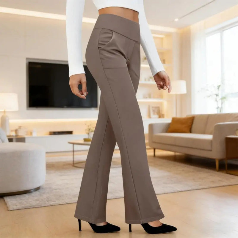 Person wearing brown flared pants in a modern living room.