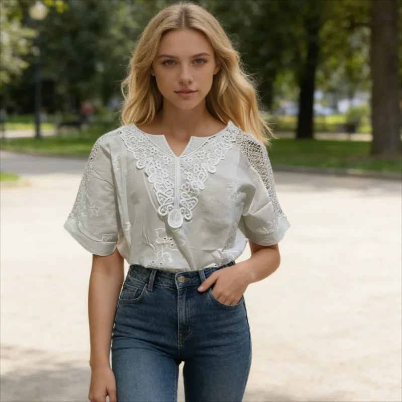 Woman wearing a white blouse with lace details and blue jeans in a park setting