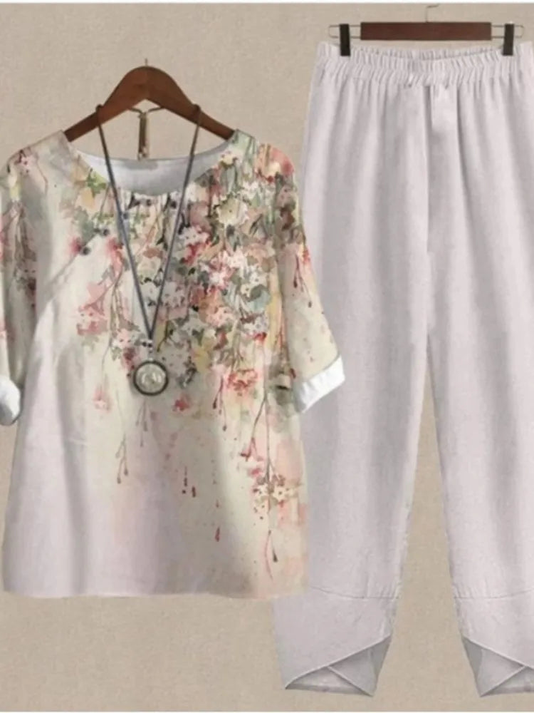 Floral dress and light pants on hangers against a neutral background