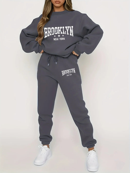 Person wearing a gray 'Brooklyn New York' sweatshirt and jogger set on a white background