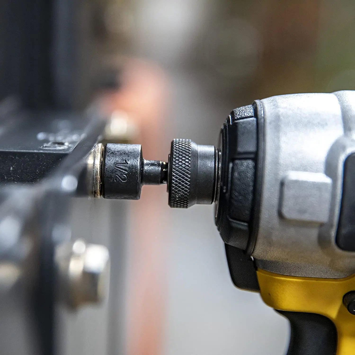 Close-up of a drill bit attached to an impact wrench with a blurred background