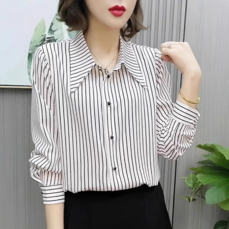 Person wearing a black and white striped shirt with a blurred background