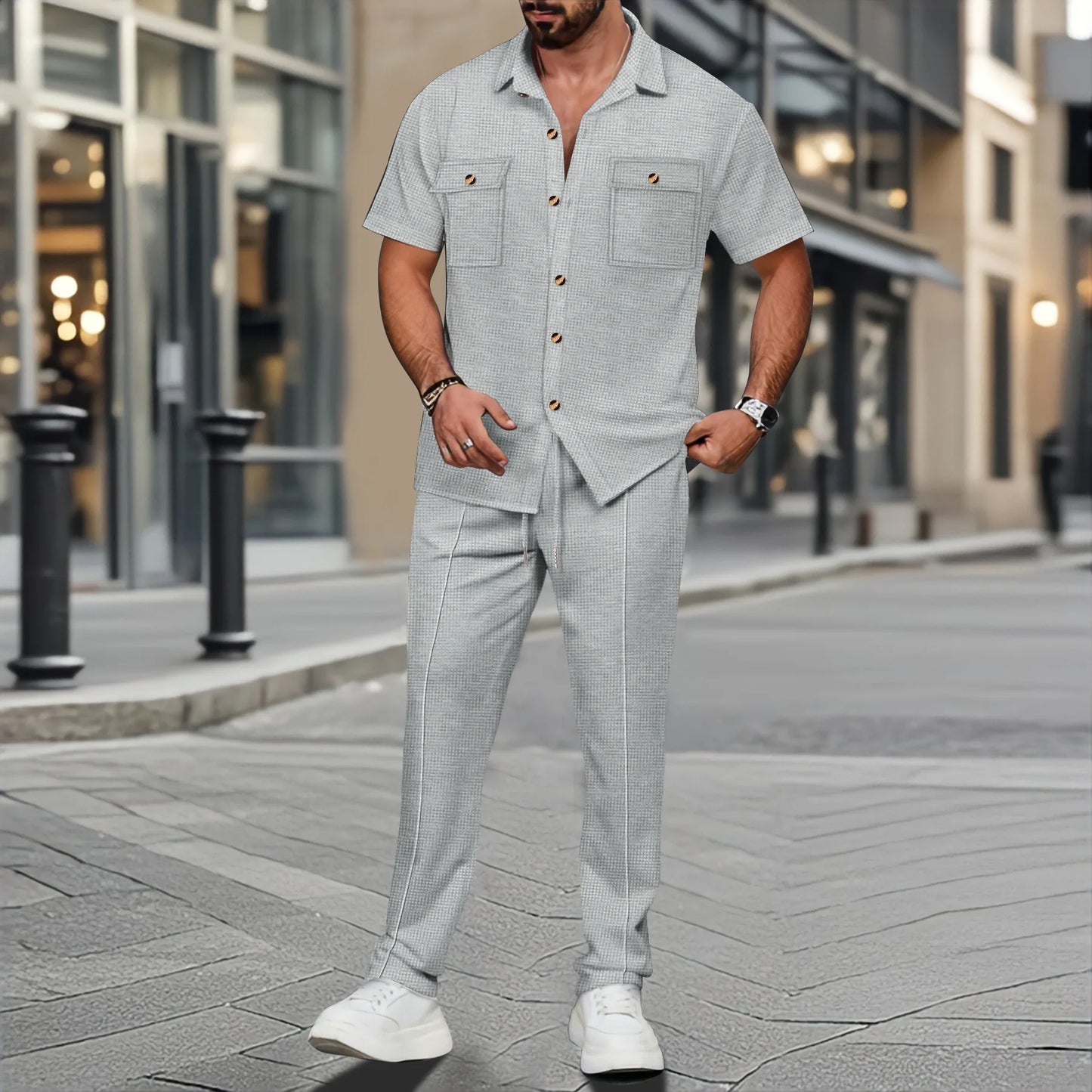 Man wearing a light gray button-up shirt and pants on a city street.