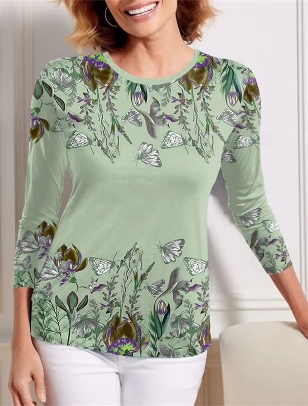 Woman wearing a green long-sleeve shirt with floral and butterfly pattern.