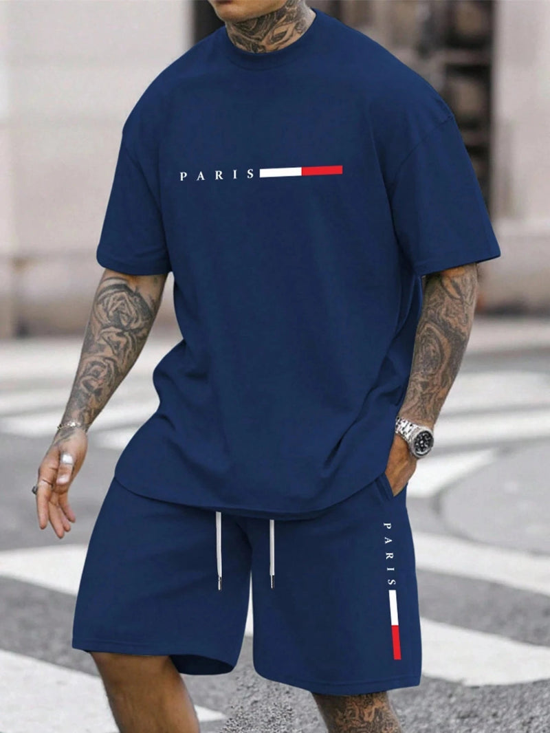 Person wearing a navy blue outfit with 'PARIS' branding on a street.