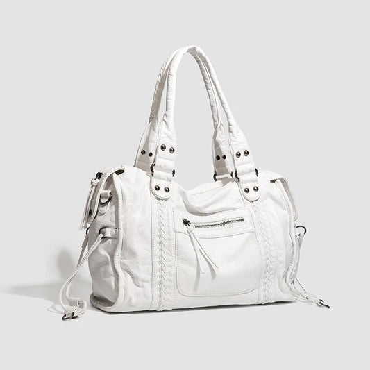 White handbag with multiple pockets and straps on a light gray background