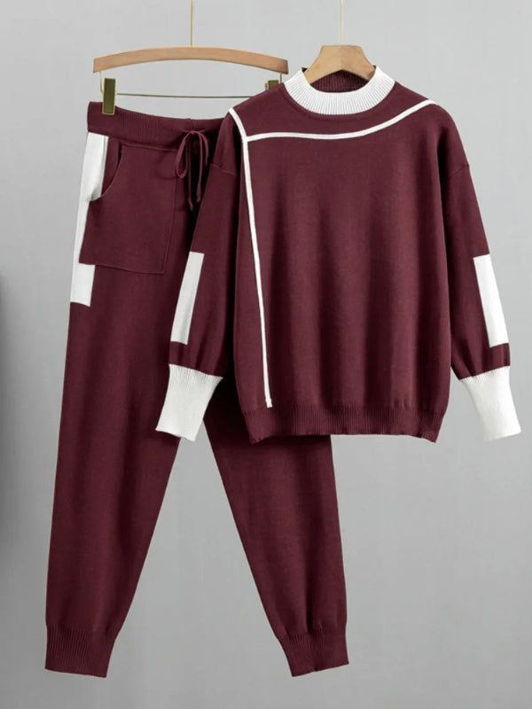 Maroon tracksuit with white accents on hangers against a gray background