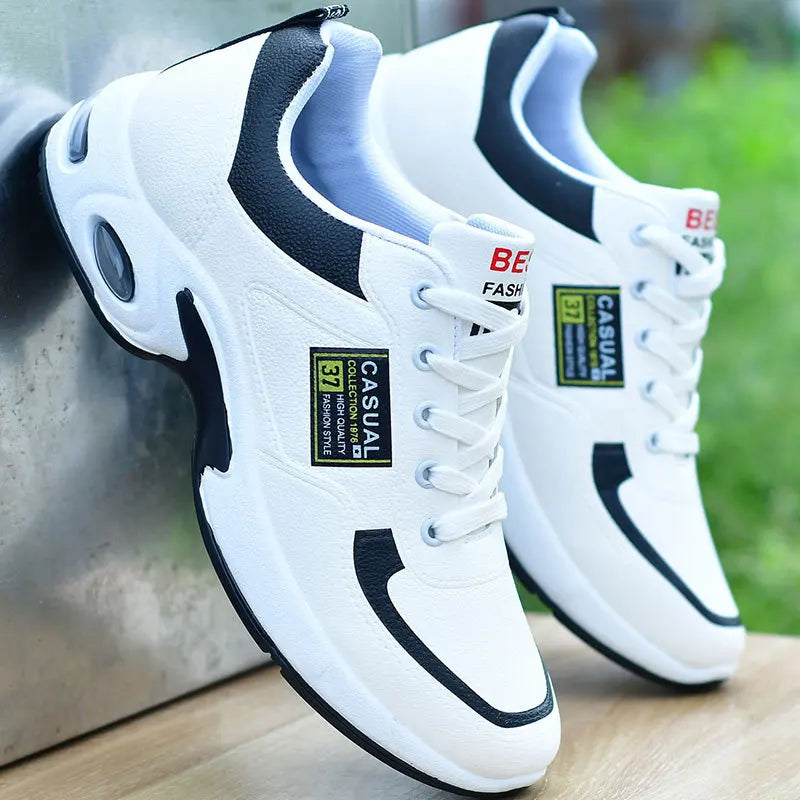 White sneakers with black accents on a wooden surface with a blurred green background