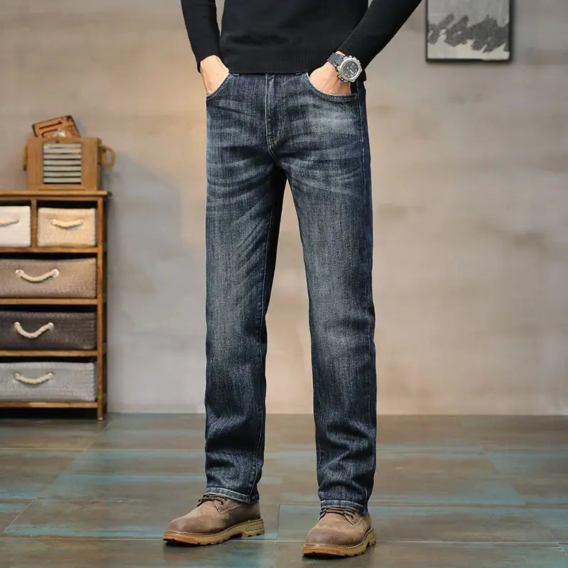 Person wearing blue jeans standing in a room with a wooden cabinet and abstract painting.