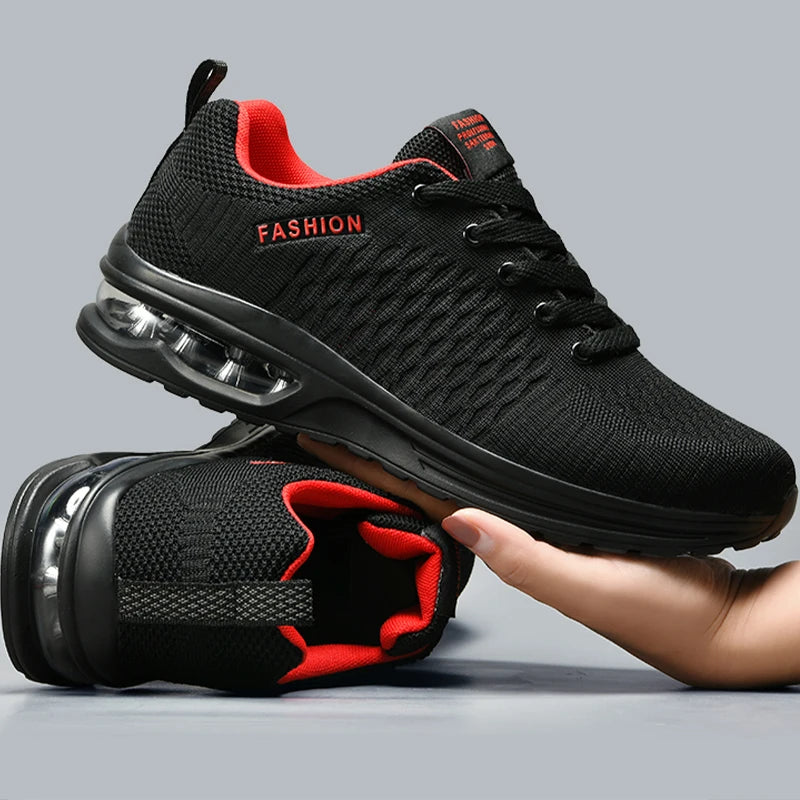 Black running shoes with red accents held by a hand on a gray background