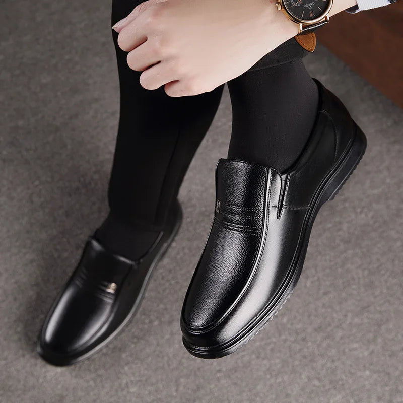 Person wearing black leather shoes on a gray background