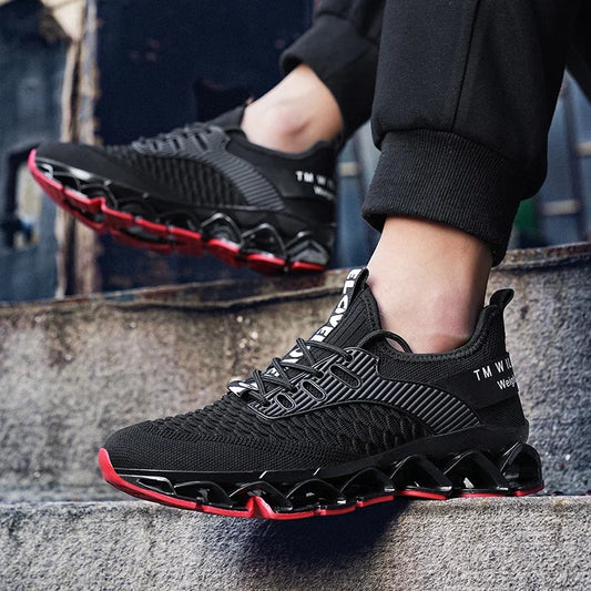 Black and red athletic shoes worn by a person sitting on steps.